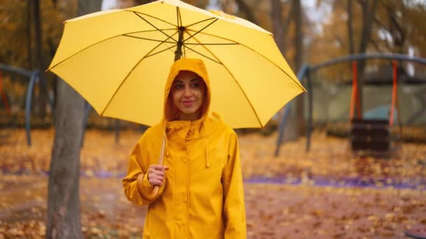 Sarı Yağmurluklu Şemsiyeli Bir Kadın Yağmurlu Bir Sonbahar Gününde Şehir — Stok video