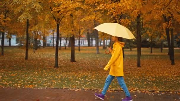 Cámara Seguimiento Foto Mujer Impermeable Amarillo Con Paraguas Brillante Camina — Vídeos de Stock