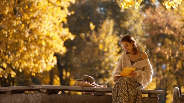 Sonbahar Parkındaki Genç Esmer Kadın Parlak Güneşe Karşı Sarı Yapraklı — Stok video