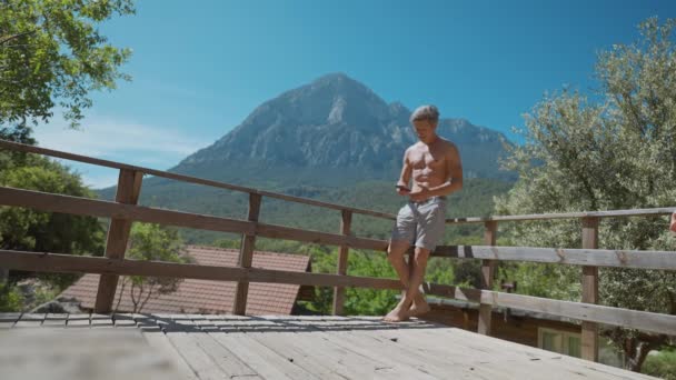 Atletik Vücutlu Yetişkin Bir Adam Arka Planda Görkemli Dağlarla Güneşli — Stok video