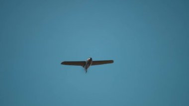 Askeri İHA keşif uçağı mavi gökyüzü yakın çekim yavaş çekimde. Modern Askeri Helikopter Teknoloji Konsepti. 4k UHD 3840x2160.