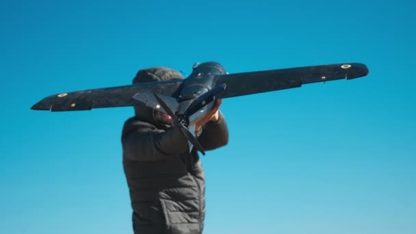 男は春の間に野原でドローンを起動する ウクライナ軍は 敵の位置を検出するために飛行機の無人機を使用しています 軍隊で近代的な技術を使用するという概念 — ストック動画