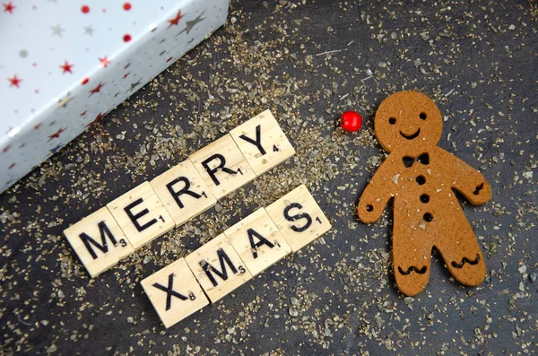 幸せなクリスマスメッセージともに現在とジンジャーブレッド男 — ストック写真