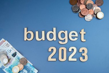 Bütçe 2023 mavi arka plan, İngiliz sikkeleri ve notları