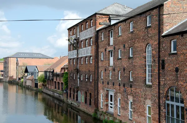 stock image Old brick warehouses converted into lofts along a river on a sunny autumn day. River Trent, Newark