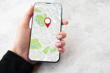 Kızlar ellerinde akıllı telefonlar ve haritalarda resimleri var. Mermer arkaplan kopyalama alanı