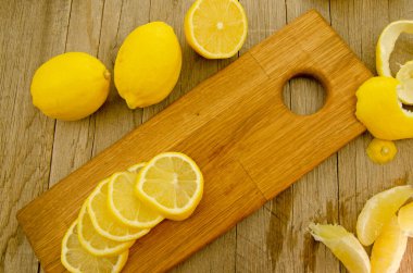 Yeni dilimlenmiş limonların ve tahta bir tahtanın üzerindeki bölümlerin üst görüntüsü..