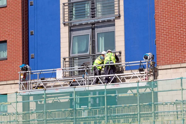 Obreros Equipo Protección Una Plataforma Suspendida Junto Edificio Lugar Construcción — Foto de Stock