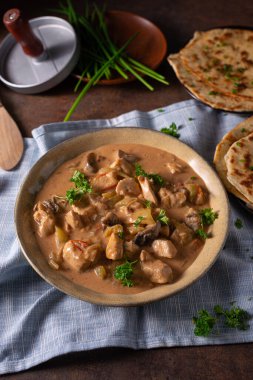 Bitkilerle ve ev yapımı naan ekmeğiyle Tikka masala