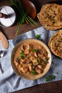 Bitkilerle ve ev yapımı naan ekmeğiyle Tikka masala