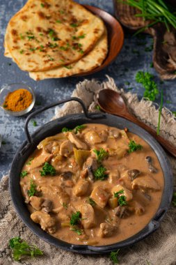 Bitkilerle ve ev yapımı naan ekmeğiyle Tikka masala