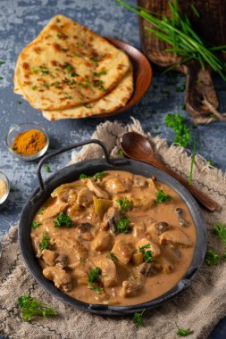 Bitkilerle ve ev yapımı naan ekmeğiyle Tikka masala