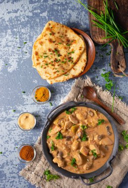 Bitkilerle ve ev yapımı naan ekmeğiyle Tikka masala