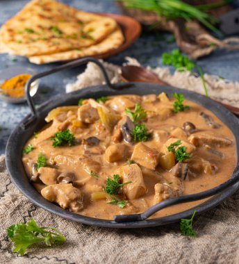 Bitkilerle ve ev yapımı naan ekmeğiyle Tikka masala