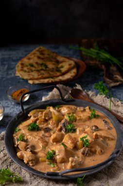Bitkilerle ve ev yapımı naan ekmeğiyle Tikka masala