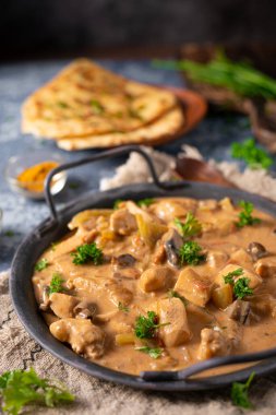 Bitkilerle ve ev yapımı naan ekmeğiyle Tikka masala