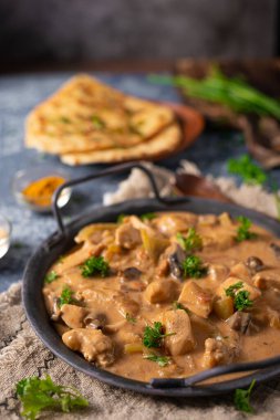 Bitkilerle ve ev yapımı naan ekmeğiyle Tikka masala