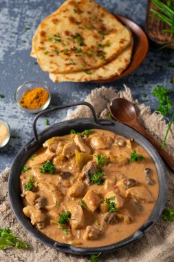 Bitkilerle ve ev yapımı naan ekmeğiyle Tikka masala