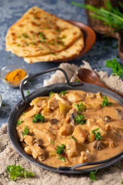 Bitkilerle ve ev yapımı naan ekmeğiyle Tikka masala