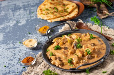 Bitkilerle ve ev yapımı naan ekmeğiyle Tikka masala