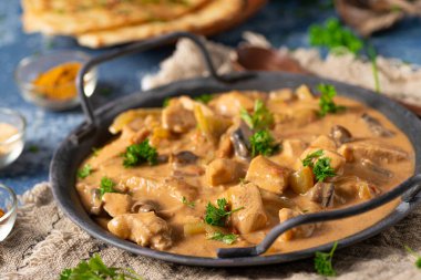 Bitkilerle ve ev yapımı naan ekmeğiyle Tikka masala