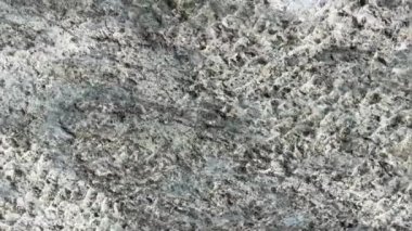 Gri taş dokusunda sudan yansıyan parlaklığın yansıması. Taşın makro fotoğrafçılığı. Doğal mineral arka planı. Yüksek kalite 4K görüntü