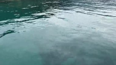 Dalgalar ve gökyüzünün yansımasıyla su üzerinde küçük dalgalar. Yüksek kalite 4k görüntü