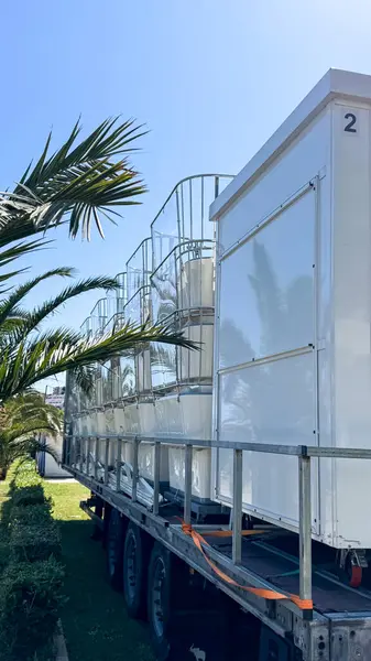 Budva, Karadağ - 18 Mayıs 2025: Dönme dolaplar katlandı ve palmiye ağaçlarıyla çevrili bir treylerde düzenlendi