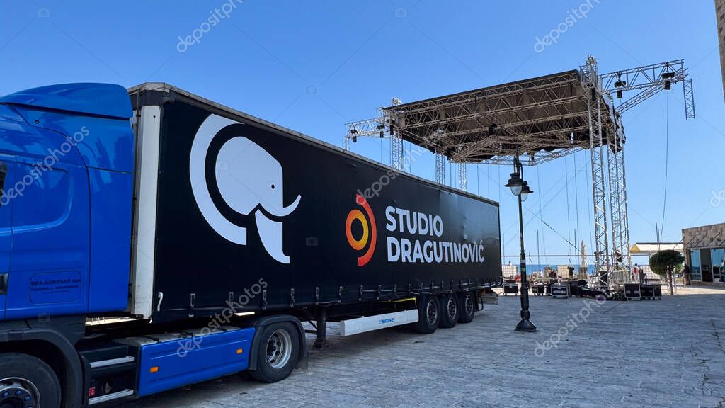 Budva, Montenegro - May 18, 2025: Studio Dragutinovic truck is parked near the stage being set up for Montenegros Independence Day.