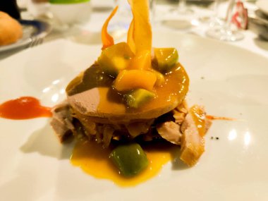 Sanat sunumunda et tabanında krema ve meyve soslu güzel bir yemek tabağı.