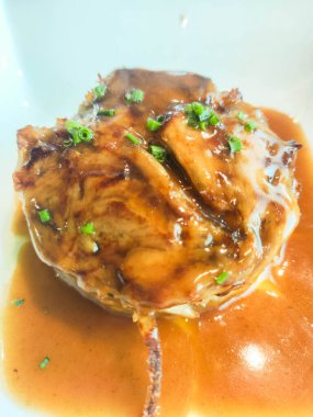 Modern gurme mutfağında servis edilen kahverengi soslu ve soğanlı ana et yemeği.