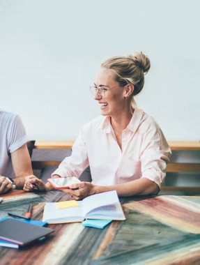 Parlak yaz terasında neşeli serbest çalışanlar konuşarak ilham kaynağı oldular. Özgürce gülüyorlar ve gülümsüyorlar. Laptopta çalışıyorlar ve sıcak gün ışığında akıllı telefon kullanıyorlar.