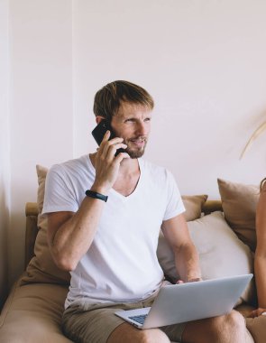 Not defterli neşeli, güzel bir kadın. Akıllı telefondan konuşan yakışıklı bir adama bakıyor. Dizüstü bilgisayarını karıştırıyor.