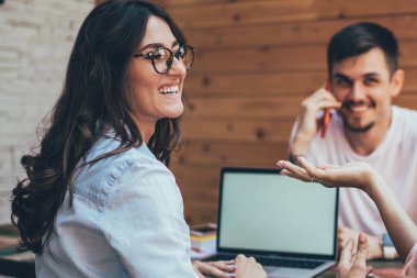 Gülen kadınlar el kol hareketleri yapıp iş hakkında tartışırken aynı anda açık kafedeki masanın etrafında oturan erkek arkadaşlarıyla buluşuyorlar.