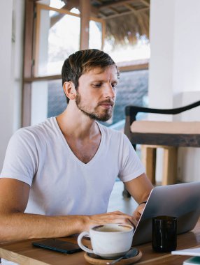 Birkaç düşünceli meslektaşımız rahat bir kafede içkilerimizi yudumluyor ve yaz günü dizüstü bilgisayarla yazı yazıyorlar.