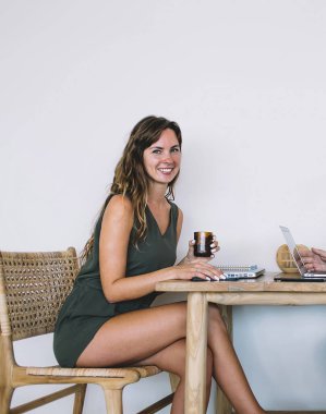 Yetişkin, yakışıklı, sakallı, günlük giysiler giymiş, kafeteryada beyaz arka planda giyinmiş neşeli, güzel bir kadının önünde meyve suyu içen bir erkek.