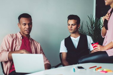 Diz üstü bilgisayarında 4G kablosuz internet sitesinde özel ders için hazır bekleyen çok kültürlü öğrenciler, üniversiteden erkek ve bayan meslektaşlar ders çalışmasında işbirliği yapıyorlar.