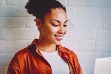 Koyu tenli hippi kız, modern dizüstü bilgisayarda kablosuz internete bağlıyken kendini iyi hisseden bir e-posta aldı. İndirme için film arayan ve boş zamanlarında izleyerek gülümseyen Afrikalı kadın.