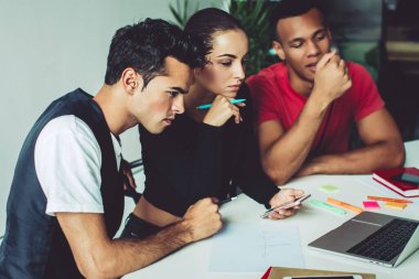 Gençlerden oluşan bir grup, modern dizüstü bilgisayarda 4G kablosuz internet sitesine bağlı olarak üniversite web sitesine yoğunlaştı, uygulamayla çok kültürlü erkek ve kadın videoları izliyor.