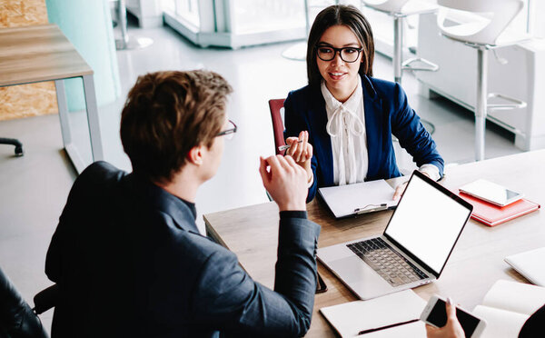 Коллеги-мужчины и коллеги-женщины сидят за рабочим столом, работают и общаются на встрече, группа опытных бизнес-партнеров обсуждает заявление для проекта, делятся креативными идеями в офисе