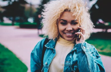 Kameraya gülümseyen mutlu bir adamın portresi pozitif arkadaşça akıllı telefon konuşmalarından keyif alırken dışarıda iletişim kurmak için gezinen interneti kullanıyor, neşeli esmer tenli kadın mobil arama yapıyor.