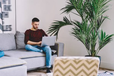 Çift, sosyal ağlardaki takipçilerle iletişim kurmak için ev internet bağlantısını kullanırken aynı zamanda oturma odasında rahat bir koltukta, teknoloji ve nesil kavramında vakit geçiriyor.