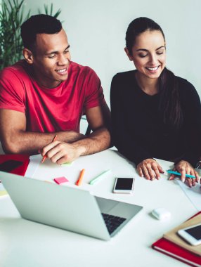 Genç, çok ırklı erkek ve kadın meslektaşların, proje stratejisi planlarken fikir alışverişinde bulunması ve fikir alışverişinde bulunması, kapalı alanlarda iş birliği yapan başarılı bir grup genç.