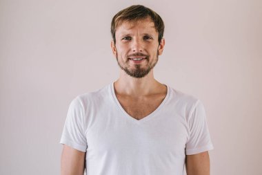 Olumlu adamın yarım boy portresi reklam arkaplanda poz verirken duvarın yanında, marka adı ya da etiketi için fotokopi alanı olan yakışıklı ve zengin bir adam kameraya bakıyor.