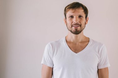 Olumlu adamın yarım boy portresi reklam arkaplanda poz verirken duvarın yanında, marka adı ya da etiketi için fotokopi alanı olan yakışıklı ve zengin bir adam kameraya bakıyor.