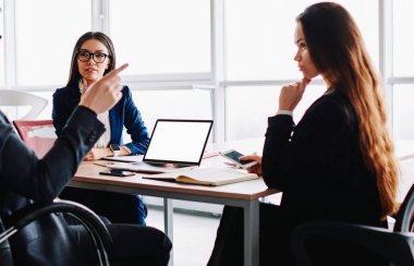 Erkek patronun resmi toplantı masasında kadın meslektaşlarıyla konuşması, profesyonel yöneticilerin masaüstünde ortak çalışma sürecinde plan ve fikir alışverişi yapması