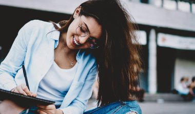 Lotus 'ta poz veren genç ve güzel bir kadın ressam şehir ortamında albüm içinde resim çiziyor. Çekici yenilikçi kız boş zamanlarında yeni bir yayın için fikirler yazıyor.