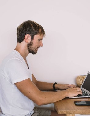 Ciddi bir erkek yazılım geliştiricisinin internete bağlanıp internete bağlanan antivirüs uygulamasını güncellemesinin yan görüntüsü, Kafkasyalı serbest yazar makaleye odaklandı