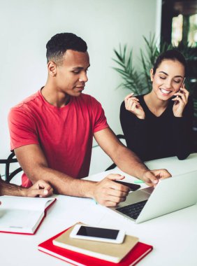 Çok ırklı iş arkadaşlarıyla yapılan beyin fırtınası sırasında internetteki web sitesi linki ile gündelik kıyafetlerle arama yapan Afrikalı Amerikalı erkek çalışanlar, başarılı bir cep telefonu araması yapan kadın.