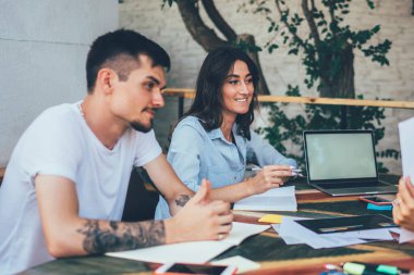 Masada elinde not defterleri ve boş ekranlı dizüstü bilgisayarla oturan arkadaşlar, gülümseyen genç bir kadın, onay kağıdından vazgeçiyor.